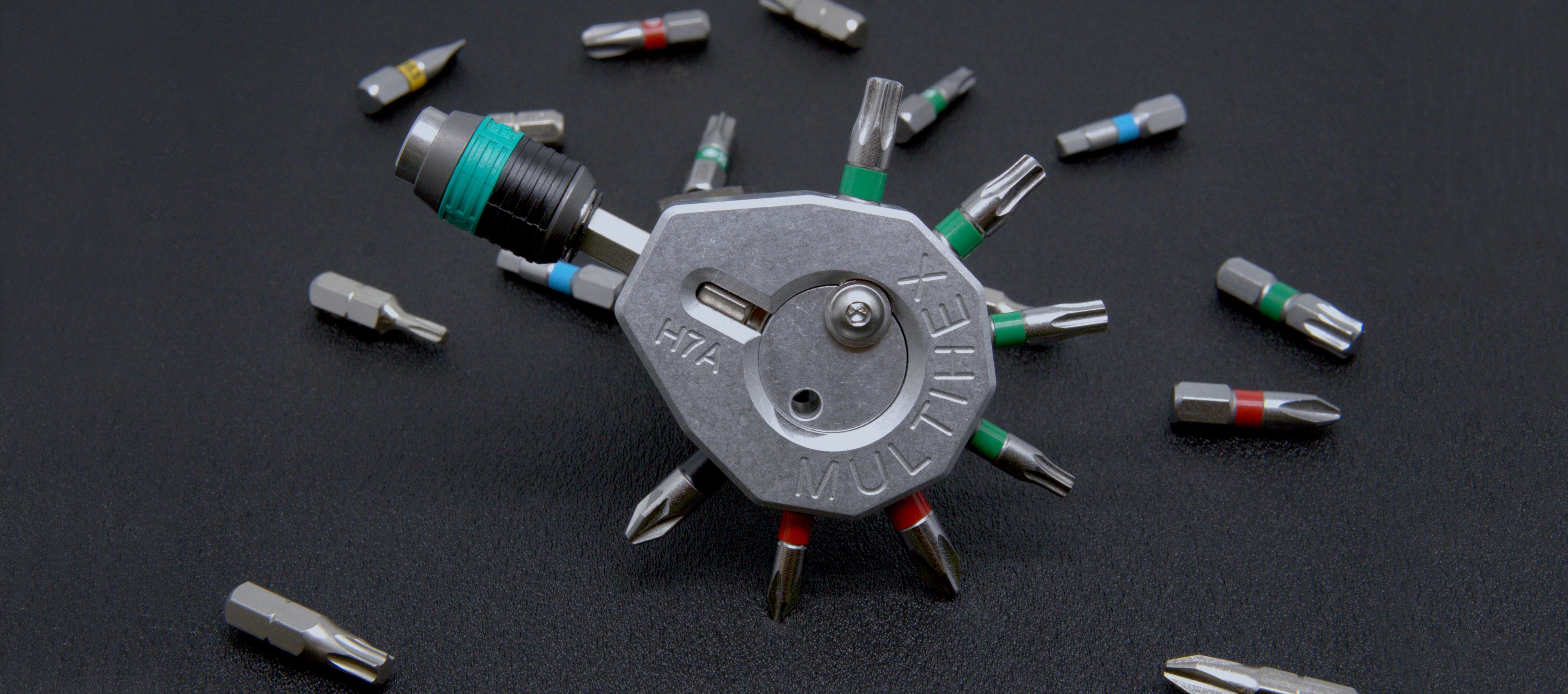 Multihex H7A: Erweiterung für Makita Akkuschrauber. Aluminium-Halter mit Platz für 7 Bits und einen Bithalter. Magnetische Befestigung der Bits. Zusätzliche Sicherung des Bithalters durch ein Druckstück. Formschlüssige Montage am Akkuschrauber. Montage freiwählbar und jederzeit änderbar(Anwendungsbeispiel mit Bits).SKU:100107120023